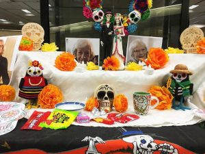 Dia de los Muertos (Day of the Dead) ofrenda (altar) at the John C. Hitt Library in 2019. Includes skulls, paper marigolds and photos of deceased authors.