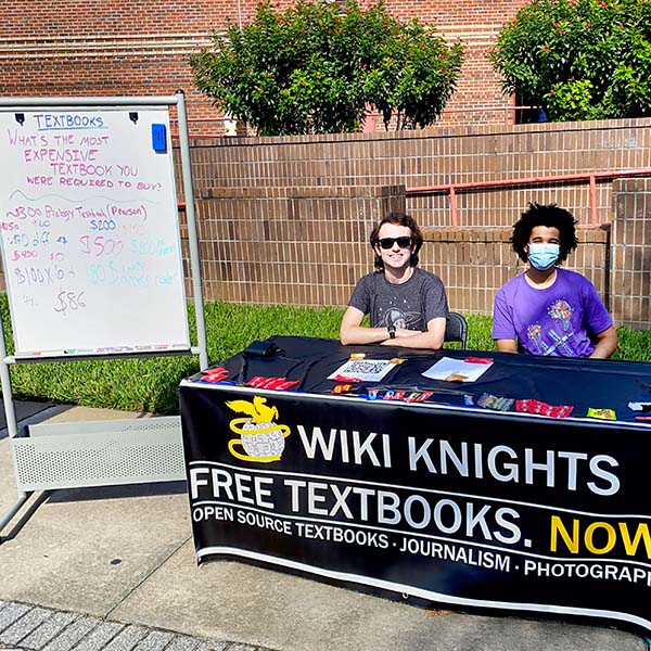 Picture of two students working outside the student union advocating for ucf students to use open source textbooks