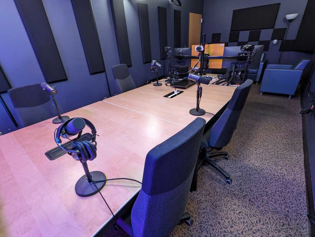 Hitt Maker recording area showing 4 chairs and microphones around a table.