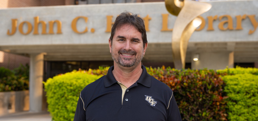 UCF Libraries Connect Librarian Andy Todd stands in from of the John C. Hitt Library on the main UCF Campus