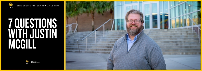 Man standing in front of library with a beard and glasses on.