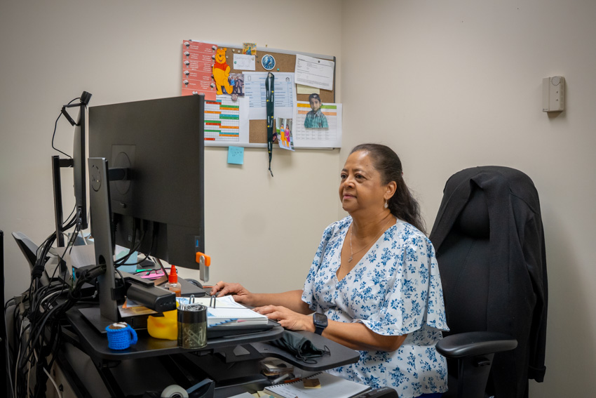 Woman working in an office at a computer.