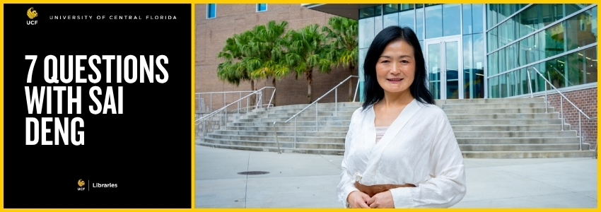 Woman with black hair standing outside of a library with stairs in the background.
